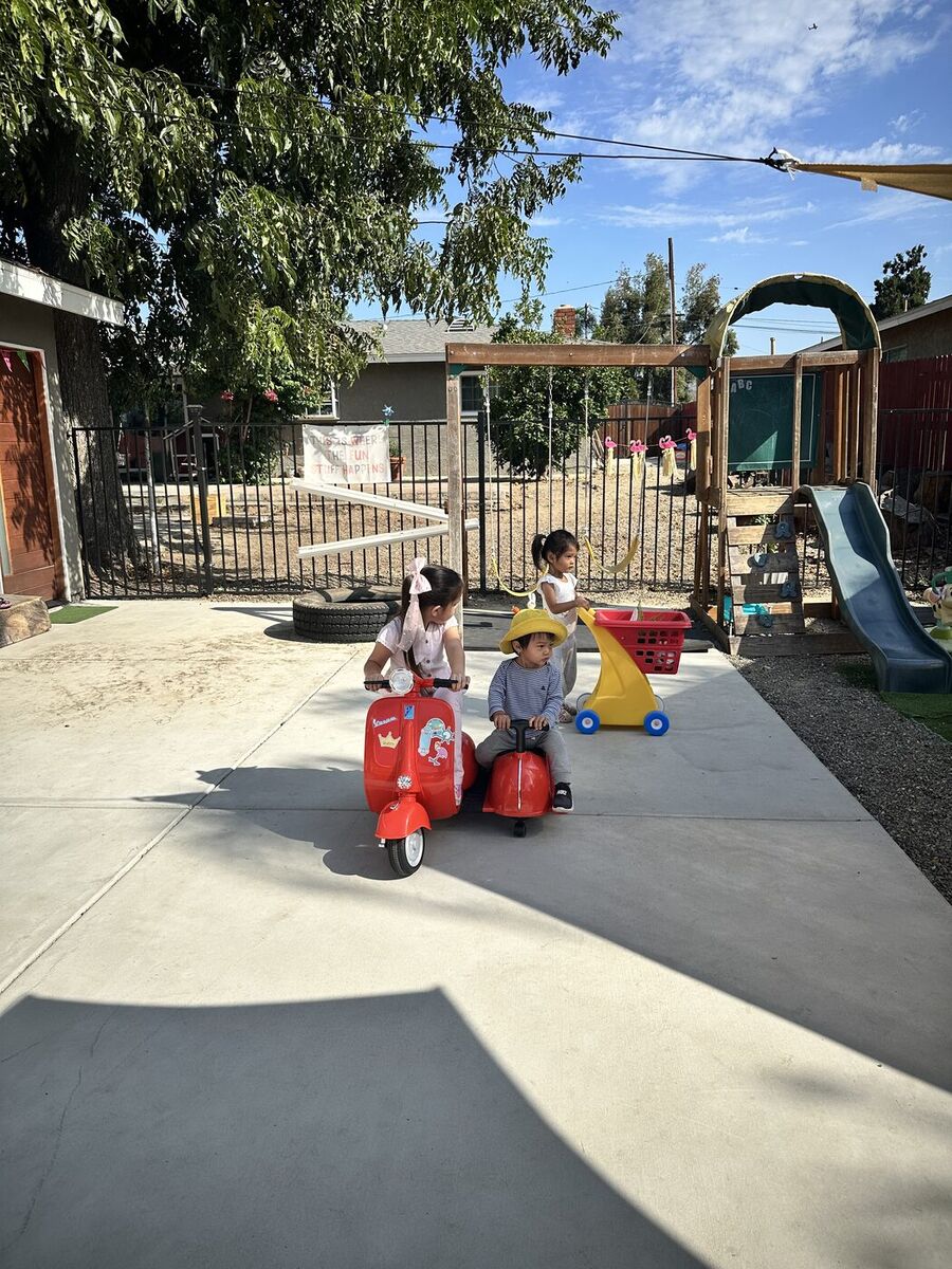 Children riding toys on the play patio